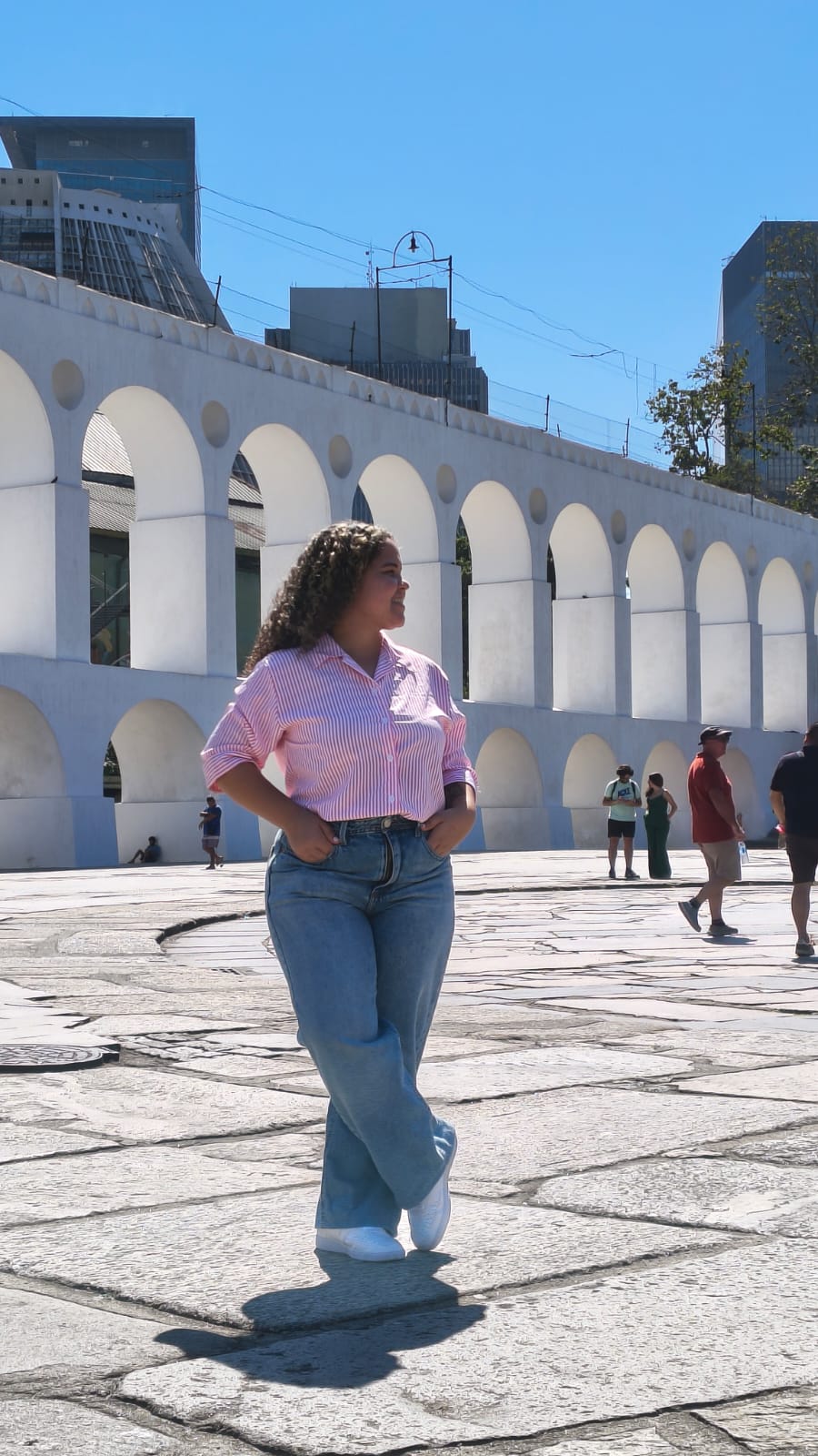 Turista posando em frente aos Arcos da Lapa